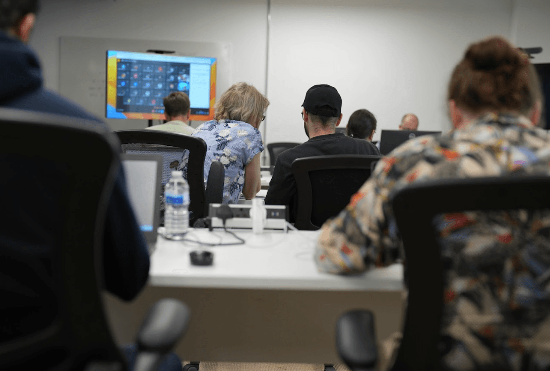 Students collaborating on code at a coding bootcamp in the UK